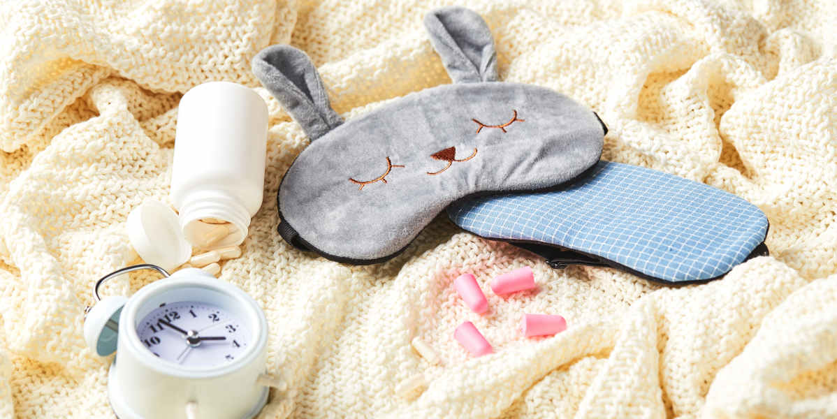Sleeping mask, alarm clock, earplugs and pills. Healthy night sleep creative concept. Good night, sleep hygiene, insomnia